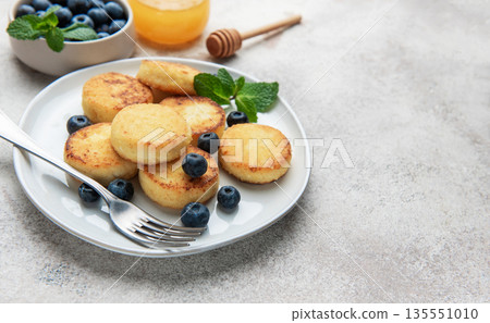 Cottage cheese pancakes with blueberries and mint on plate 135551010