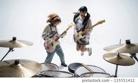女子樂團的吉他手兼主唱在演奏時活力四射地跳躍。 女子樂團的吉他手兼主唱在演奏時活力四射地跳躍。 135551412