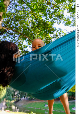 Child Peeking Over Hammock in Park 135552013