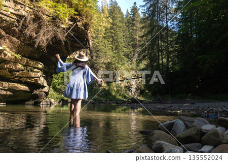 Woman Strolling by River in Forest Woman Strolling by River in Forest 135552024