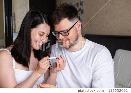 Happy Couple Celebrating Positive Pregnancy Test 135552031