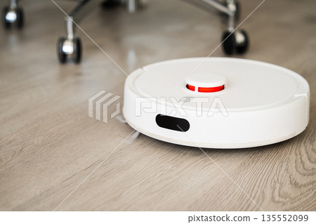Robotic vacuum cleaner cleaning wooden floor in modern smart home interior, automated household robot technology Robotic vacuum cleaner cleaning wooden floor in modern smart home interior, automated household robot technology 135552099