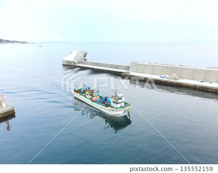 冬季,從空中俯瞰北海道森町石倉漁港,漁船緩緩駛入港口。 冬季,從空中俯瞰北海道森町石倉漁港,漁船緩緩駛入港口。 135552159