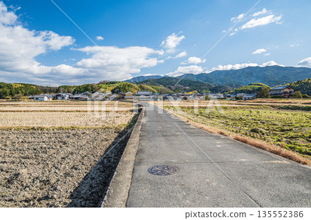 A road running through rice fields in Asuka Village, Nara Prefecture A road running through rice fields in Asuka Village, Nara Prefecture 135552386