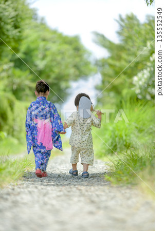 Back view of a brother and sister walking in yukata Back view of a brother and sister walking in yukata 135552549