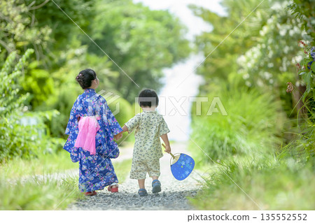 Back view of a brother and sister walking in yukata Back view of a brother and sister walking in yukata 135552552