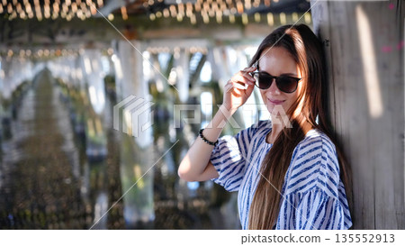 Smiling woman in sunglasses under pier in Sopot Poland 135552913
