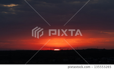 Fiery Red Sunset Over Distant City Horizon 135553265