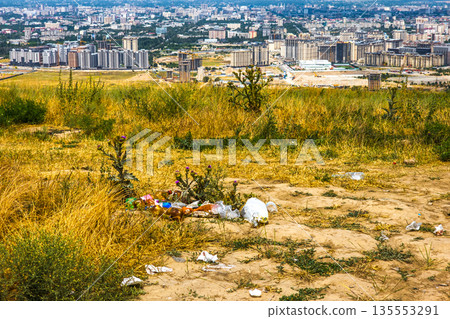 Trash littering on hillside with Bishkek cityscape background 135553291