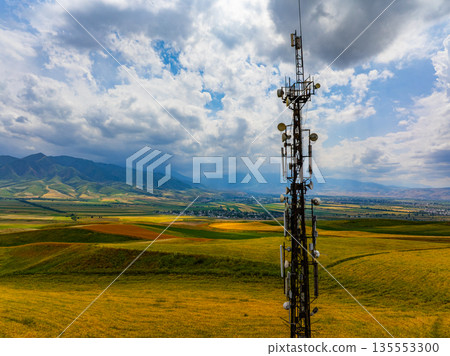 Telecommunications Tower in Rural Landscape with Distant Mountains 135553300