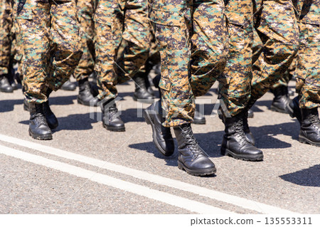 Group of soldiers marching in camouflage trousers outdoors Group of soldiers marching in camouflage trousers outdoors 135553311