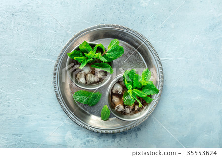 Mint Julep in the Kentucky Derby classic silver glass, with fresh mint leaves Mint Julep in the Kentucky Derby classic silver glass, with fresh mint leaves 135553624