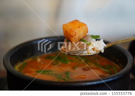 Delicious Korean Sundaegukbap (blood sausage rice and soup) served in a steaming earthenware pot with radish kimchi (Kkakdugi). Delicious Korean Sundaegukbap (blood sausage rice and soup) served in a steaming earthenware pot with radish kimchi (Kkakdugi). 135553776