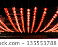 Chinese red lamps with bright light inside hanging on the cable lines over the street at night. 135553788