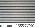 Rough cement wall in grey color covered by shadow in stripped lines from the sunlight through the window. 135553790