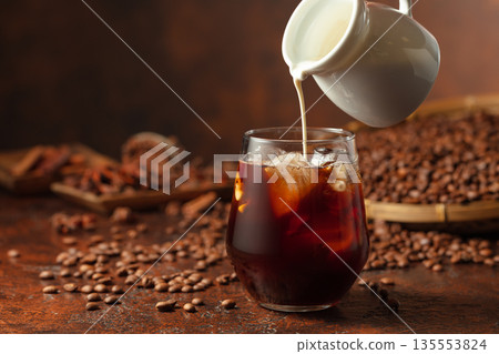 Iced coffee with cream on a brown table. 135553824