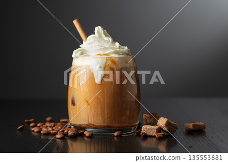 Iced coffee with whipped cream and caramel sauce. 135553881