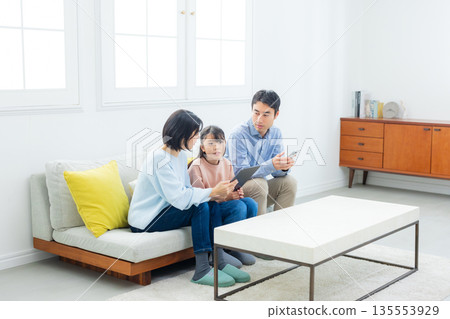 Family looking at a smartphone in the living room 135553929