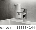 New 2026 trend Cloud Dancer color. Modern bathroom setup in a minimalist interior, featuring a chrome faucet and automatic, touchless soap dispenser. 135554144
