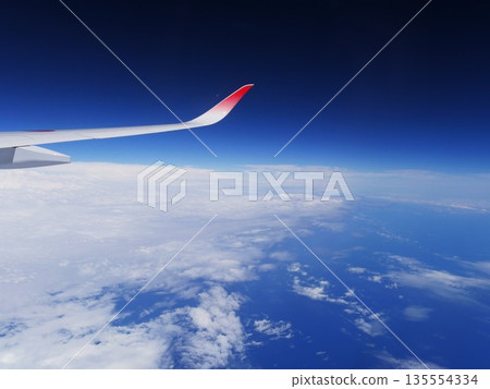飛機在空中飛行的景像以及飛機機翼。 飛機在空中飛行的景像以及飛機機翼。 135554334