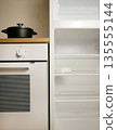 Empty Refrigerator and Built-In Oven with Pot on Stove in Modern Kitchen Interior 135555144