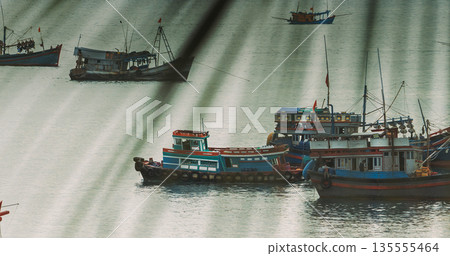 Fishing boats anchored in harbor seen through cable shadows, Phu Quoc Vietnam 135555464