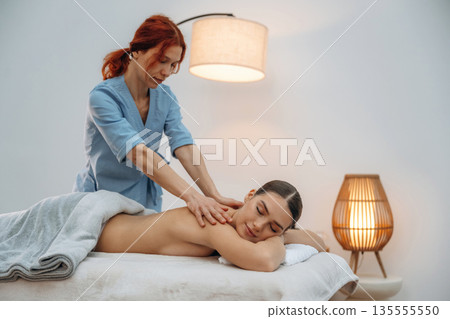 Neck massage. Relaxed young woman is with therapist in spa salon Neck massage. Relaxed young woman is with therapist in spa salon 135555550