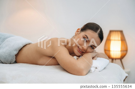 Relaxing, waiting. Beautiful young woman lying on a couch in a spa salon 135555634