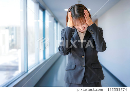 Business woman holding a head Business woman holding a head 135555774