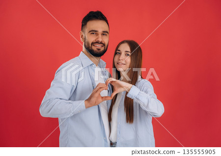 Showing heart gesture by hands. Lovely couple are together in the studio 135555905