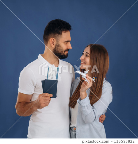 Standing and smiling. Couple are ready to travel, with tickets 135555922