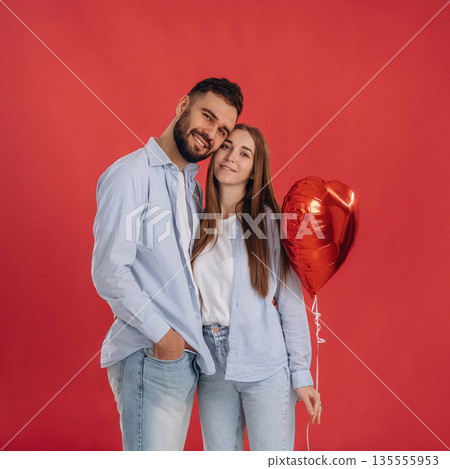 Posing, holding balloon. Lovely couple are together in the studio 135555953