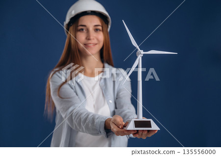 Woman engineer electrician is holding toy wind generator 135556000