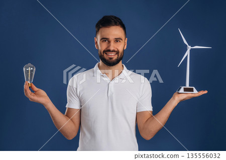 Electrician is holding wind generator toy, conception of eco energy 135556032