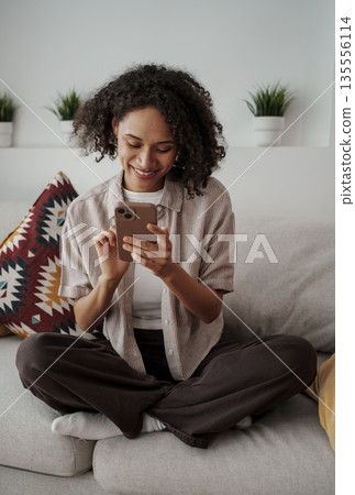 Woman Reading Smiling, Young Lady Enjoying Phone Message, Girl Relaxing On Couch With Gentle Smile Woman Reading Smiling, Young Lady Enjoying Phone Message, Girl Relaxing On Couch With Gentle Smile 135556114