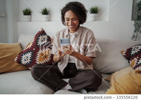 Calm Woman Carefully Inspects Different Offers And Special Discounts On Ecommerce Websites Calm Woman Carefully Inspects Different Offers And Special Discounts On Ecommerce Websites 135556120