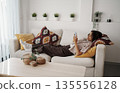 Woman Lying Comfortably On Sofa, Serene Lady Reclined On Couch While Scrolling Through Her Device 135556128