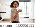 Approachable Black Woman Smiling Warmly While Holding Coffee In Contemporary Kitchen Ambiance 135556133