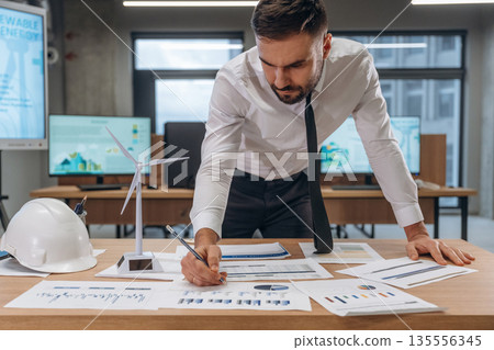 Project planning, construction. Man is working in the wind turbine company 135556345