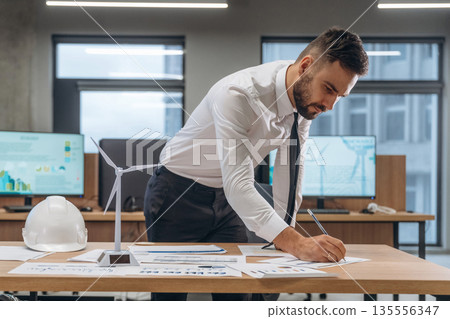 Project planning, construction. Man is working in the wind turbine company Project planning, construction. Man is working in the wind turbine company 135556347