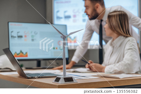 Sharing ideas, talking. Two employees are working in wind turbine company 135556382