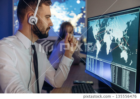 Map on the display. People are working by computers in airline company Map on the display. People are working by computers in airline company 135556476