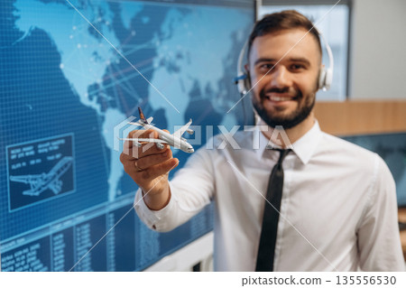 Cheerful facial expression. Man is holding toy plane, in airline company 135556530