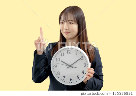 Business woman pointing at the clock Business woman pointing at the clock 135556851