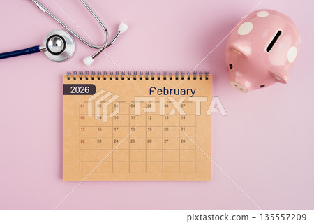 February 2026 desk calendar and stethoscope with piggy bank. Savings for Health concept. 135557209