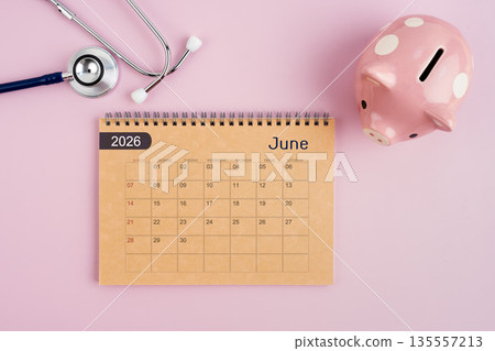 June 2026 desk calendar and stethoscope with piggy bank. Savings for Health concept. June 2026 desk calendar and stethoscope with piggy bank. Savings for Health concept. 135557213