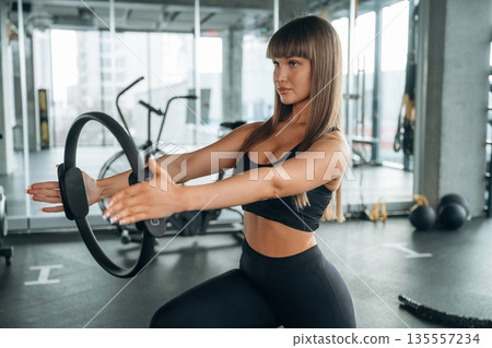 Elastic ring in hands. Young woman is in the gym 135557234