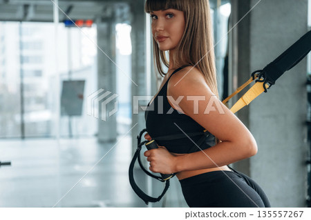 Process of training, exercise for arms. Young woman is in the gym 135557267