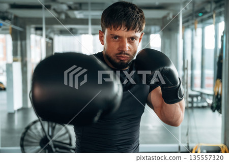 Black boxing gloves. Man is in the modern gym 135557320