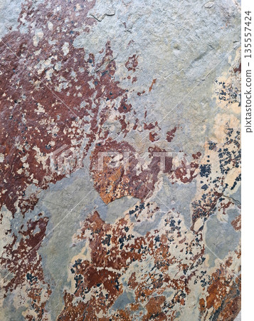 A close view shows stone wall tiles in rusty and black colors. The surface displays an interesting texture with various shades and patterns. The natural look adds to the wall's design. 135557424